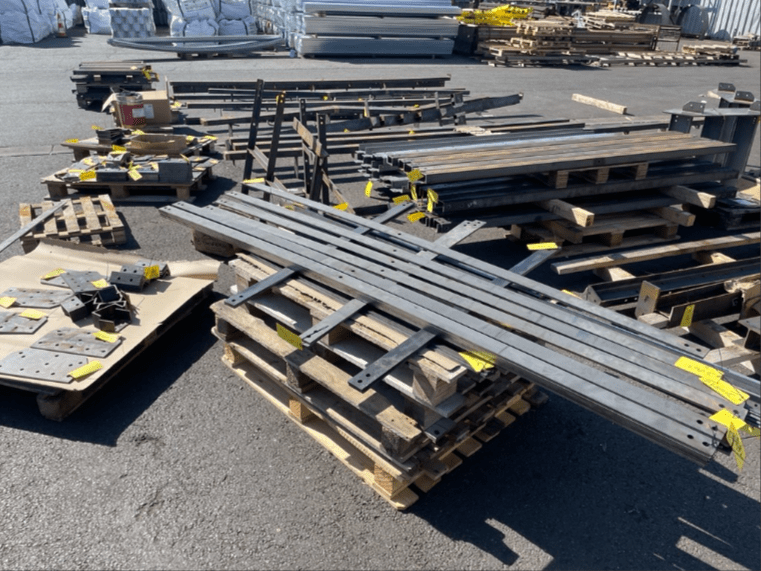 Pièces métalliques triées et étiquetées sur palettes, prêtes pour galvanisation à chaud et thermolaquage