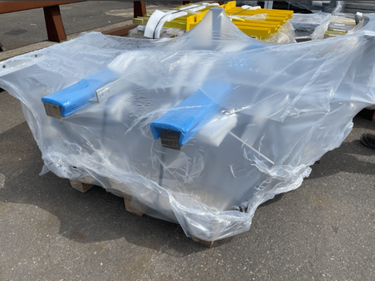 Pièces métalliques emballées sous film plastique avec protections mousse bleue, prêtes à la livraison