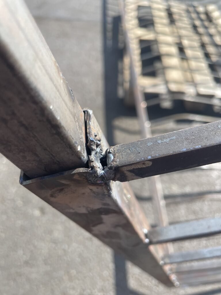 Mauvaise soudure avec excès de matière et laitier visible.